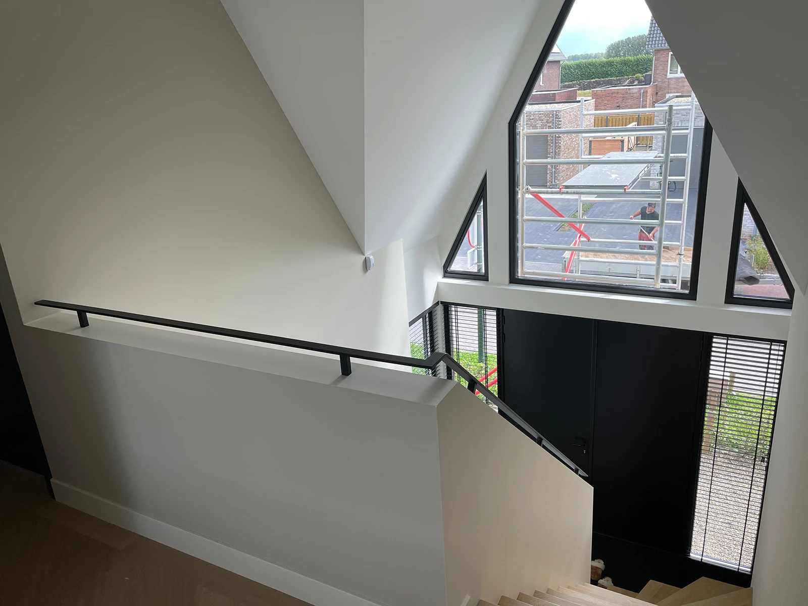 Stalen zwarte trapleuning over muur heen